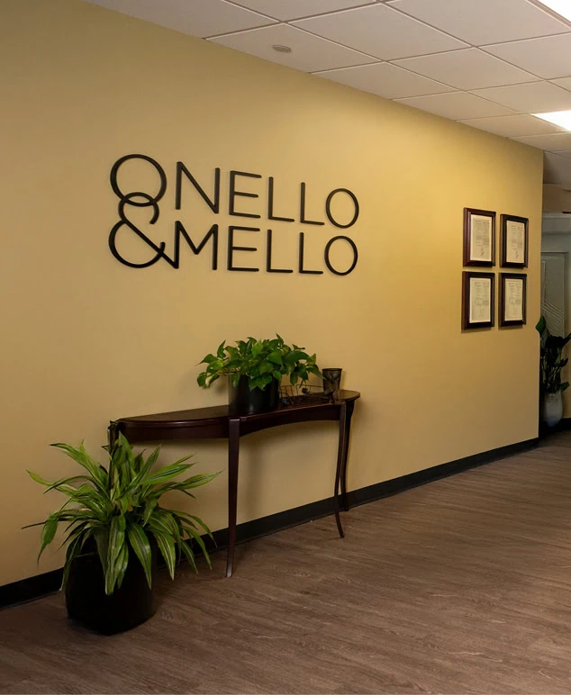 A yellow wall with a sign that reads Onello & Mello with a table and plants