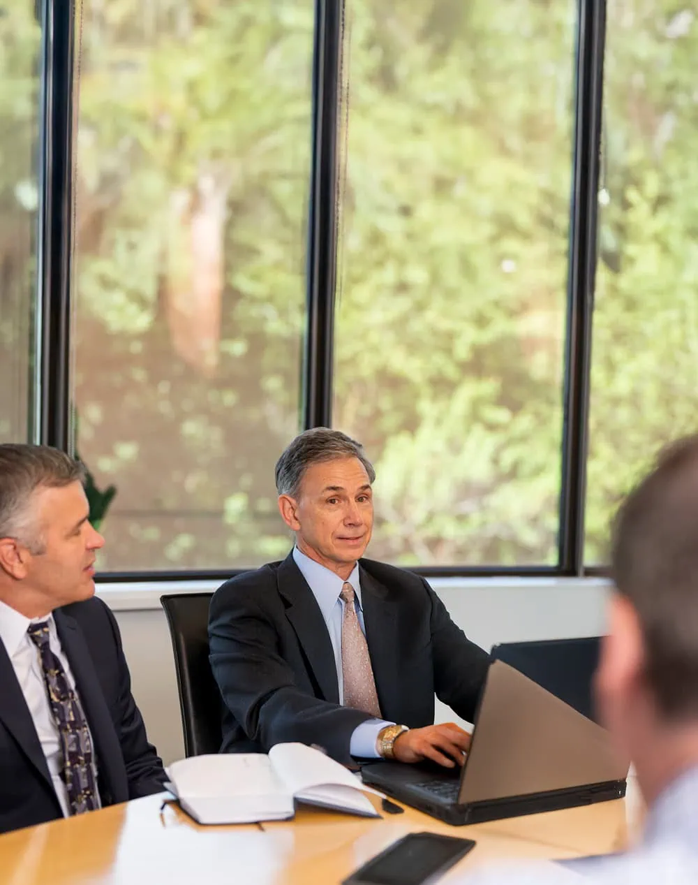 A copyright and trademark attorney sitting at a conference room table with a laptop computer